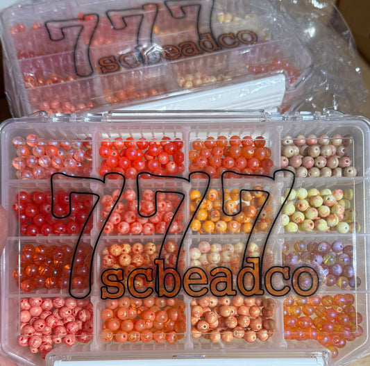 Clear plastic container with compartments filled with small beads, branded '777 scbeadco'.